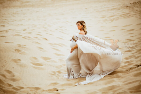 zwangerschapsreportage op het strand in luxe jurk